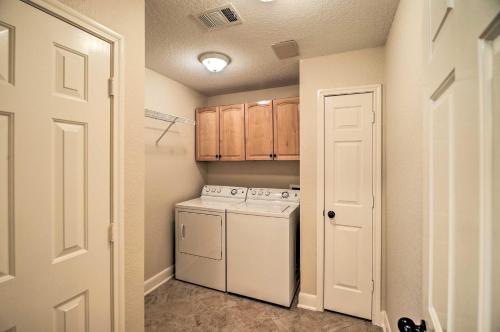 a small kitchen with a white stove and a washer at Apt with Balconies - Steps to Kemah Boardwalk! in Kemah