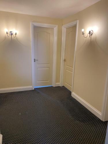 an empty room with two doors and a hallway at Stansted Airport Guest Rooms in Bishops Stortford