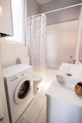 a white bathroom with a washing machine and a sink at V6 Apartment by Small Home Budapest in Budapest