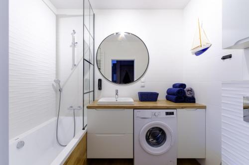 y baño con lavadora y espejo. en Apartament Marynarska Aquapark, en Reda
