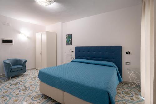 a bedroom with a blue bed and a chair at Park Hotel Villa Maria in San Menaio