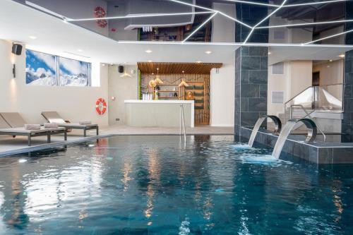 uma piscina interior com escorregas num edifício em Hôtel VoulezVous by Les Etincelles em Tignes