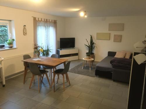 a living room with a table and a couch at Souterrain Ferienwohnung im Acherner Weg in Achern