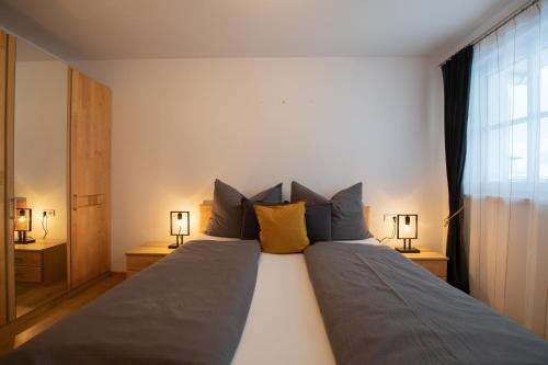a bedroom with a large bed with two lamps at Mountainfloor in Grossarl