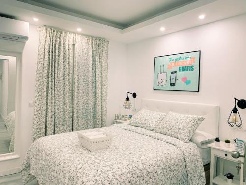 a white bedroom with a bed and a window at La Placita Boutique Centro in Málaga
