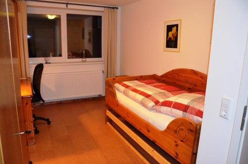 1 dormitorio con cama de madera y ventana en "Libelle am Bernsteinsee" Zimmer in Stüde, Sassenburg, en Sassenburg