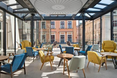 a room with chairs, tables, chairs and umbrellas at Hotel Unicus Palace in Kraków