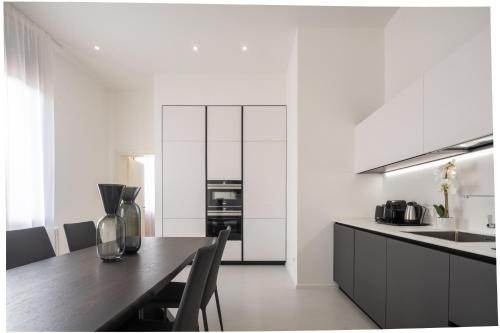 a kitchen with white walls and a wooden table at Design Apartment with Balcony on the Grand Canal R&R in Venice