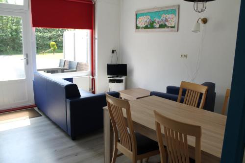 a living room with a table and a couch and a table and chairs at boerderij de duinen 111 in De Cocksdorp