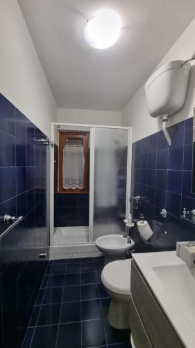 a bathroom with a toilet and a sink and a shower at Appartamento immerso nella natura in Frontignano
