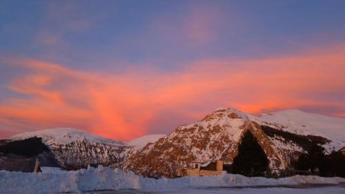 une maison dans la neige devant une montagne dans l'établissement Appartamento immerso nella natura, à Frontignano