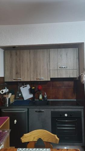 a kitchen with a black counter and wooden cabinets at Appartamento immerso nella natura in Frontignano