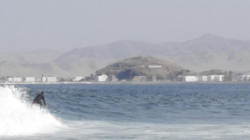 a man riding a wave on a surfboard in the ocean at Bungalows Cerro Azul in Cerro Azul