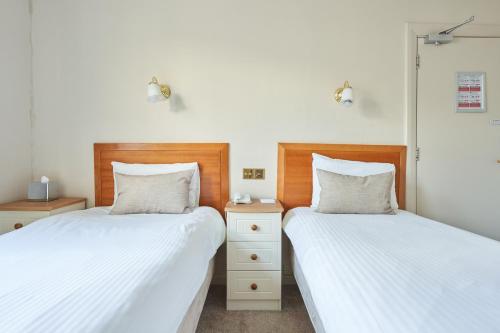 two beds sitting next to each other in a bedroom at Great Western in Newquay