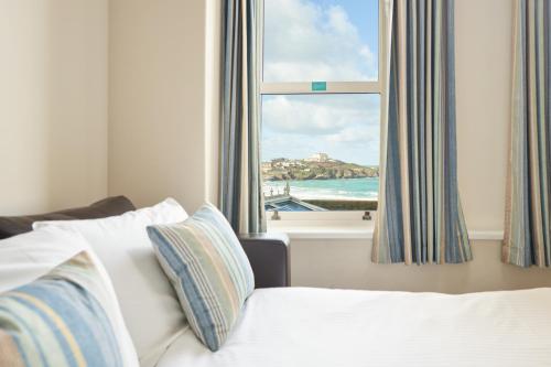 a bedroom with a window with a view of the ocean at Great Western in Newquay