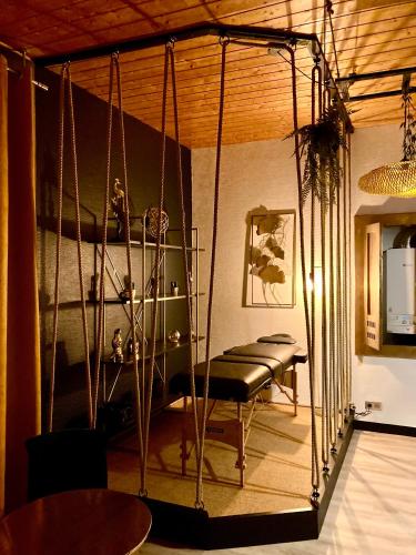 - une balançoire dans un salon avec une table dans l'établissement SUITE KASSIOPEE, romantisme, balnéo, sauna, à Quimperlé