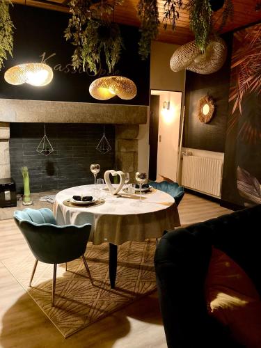 une salle à manger avec une table, des chaises et des lumières dans l'établissement SUITE KASSIOPEE, romantisme, balnéo, sauna, à Quimperlé