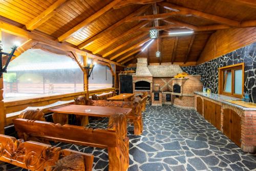 a dining room with wooden tables and a fireplace at Pensiunea Paradisul Verde in Moisei