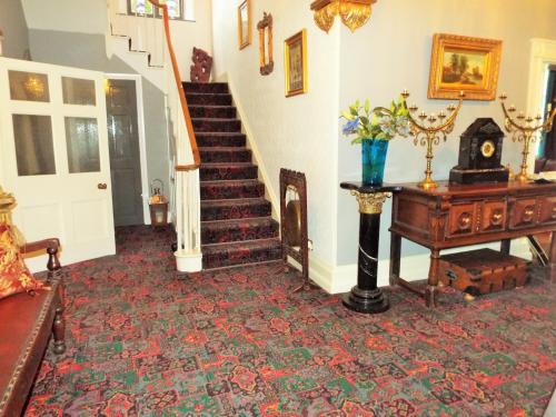 a living room with a staircase and a table at Old Vicarage B&B in Coleford