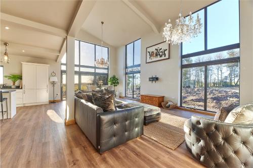 a living room with two couches and a chandelier at Host & Stay - High Bellridge Farm in Kirkheaton