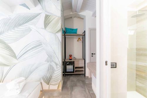 a bedroom with a bed with a large leafy wall at Carizza Rooms in Pozzallo