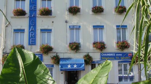 a white building with blue and white signs on it at Hôtel de la Gare in Cherbourg en Cotentin