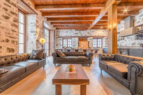 a living room with leather couches and a table at Villa Molin Del Faure in Alleghe