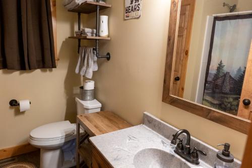 a bathroom with a sink and a toilet and a mirror at NEW!! House Near Raystown Lake in Peaceful Wooded Area in Huntingdon