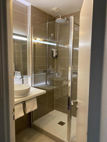 a bathroom with a glass shower and a sink at Atlantic Hôtel - L'Ile d'Yeu in L'Ile d'Yeu