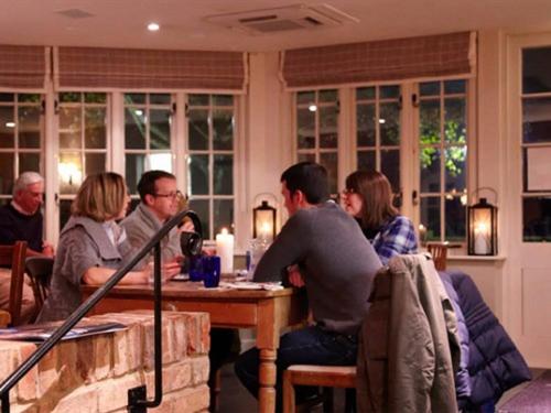 un grupo de personas sentadas en una mesa en un restaurante en The Three Daggers en Edington