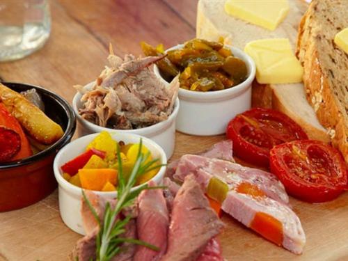 a wooden table with different types of food on it at The Three Daggers in Edington