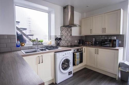 a kitchen with a washing machine and a sink at Shepherd's Rest Apartments Central Location With Parking in Tewkesbury