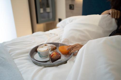 a tray of food and a cup of coffee and orange juice at Carizza Rooms in Pozzallo