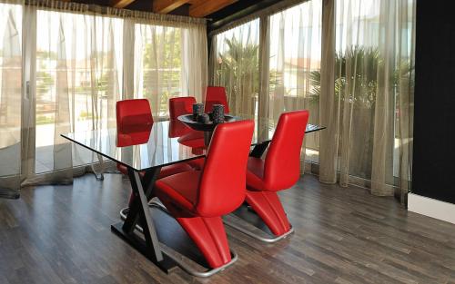 a dining room with red chairs and a table at Hotel In - Lounge Room in Cazzago di Pianiga