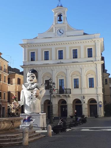 a statue in front of a building with a clock tower at Casetta la Terrazza in Civita Castellana