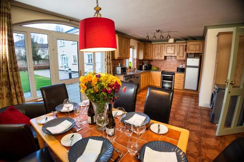 a dining room with a table with flowers on it at 21 Killarney Holiday Village in Killarney