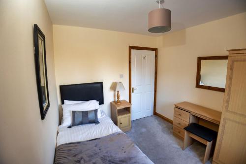 a bedroom with a bed and a desk and a mirror at 21 Killarney Holiday Village in Killarney