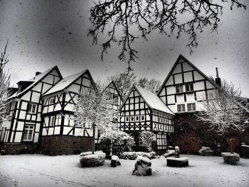 una foto en blanco y negro de una casa cubierta de nieve en Fünf Giebel Eck in der Freiheit am Ruhrtalradweg, en Wetter