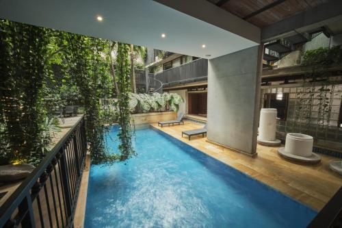 an indoor pool with blue water in a building at Alko Hotel Casa Nispero in Cali