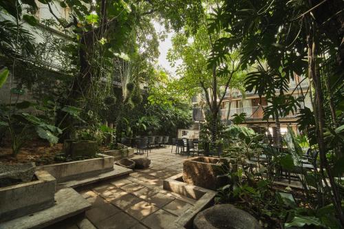 a courtyard with chairs and trees in a building at Alko Hotel Casa Nispero in Cali