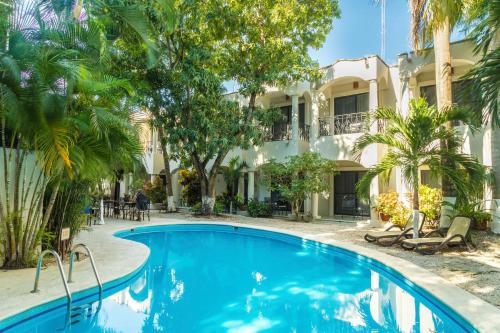 a swimming pool in front of a building at Hacienda Paradise Hotel in Playa del Carmen