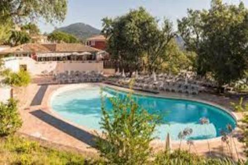 - une grande piscine avec des chaises dans un complexe dans l'établissement Appartement 4 ou 5 pers Vue Mer Climatisé Golfe de St Tropez Grimaud Les Restanques, à Grimaud