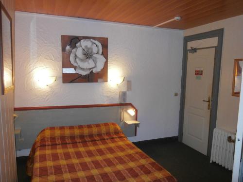 a hotel room with a bed and a picture on the wall at Hotel Beausejour in Rouen