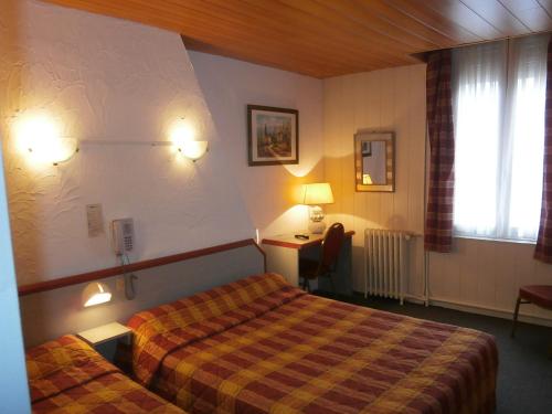 Habitación de hotel con 2 camas y escritorio en Hotel Beausejour, en Rouen