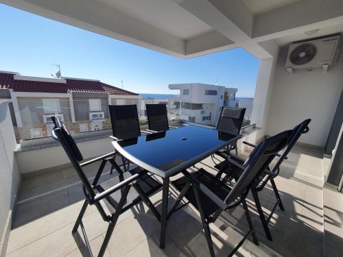 einen Tisch und Stühle auf einem Balkon mit Aussicht in der Unterkunft Aquarius Luxury apartment with pool and sea view in Novalja