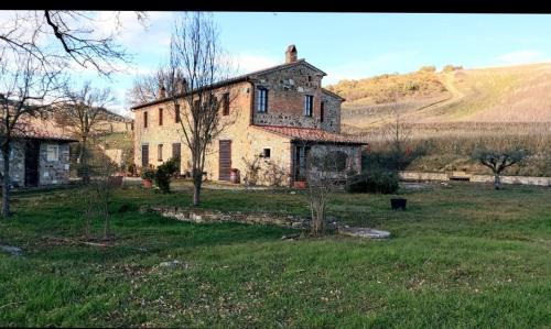 an old house in the middle of a field at Molino della Tuoma in San Quirico dʼOrcia