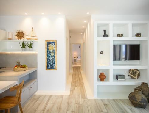 a kitchen with white walls and a dining room with a table at Soleila Mykonos Villa in Kalafatis