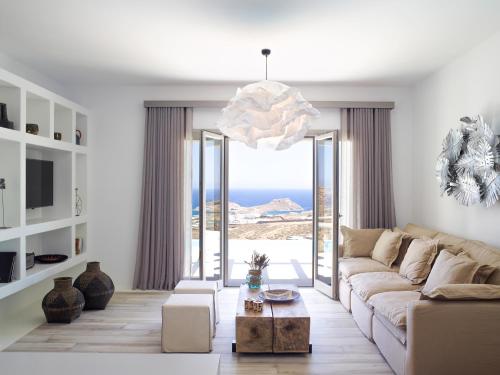 a living room with a couch and a view of the ocean at Soleila Mykonos Villa in Kalafatis