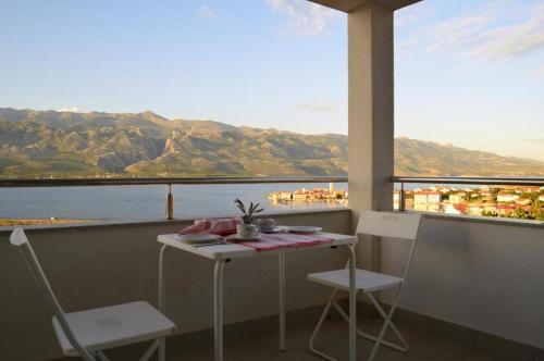 una mesa y sillas en un balcón con vistas en Seashell Vinjerac, en Vinjerac