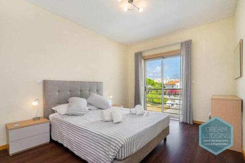 een slaapkamer met een bed en een groot raam bij Medronheira B2 Dream Lodging in Albufeira